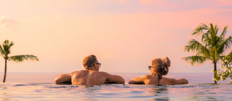 Couple at sunset in infinity pool overlooking ocean